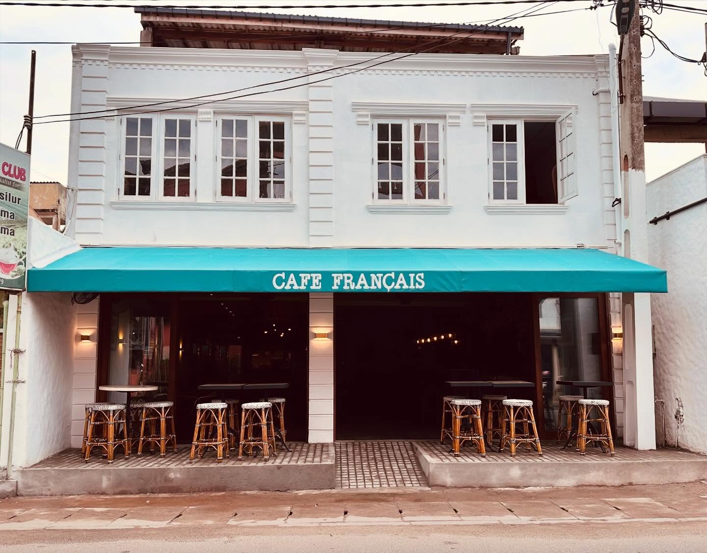 Café Français dining room with warm wood and tropical light