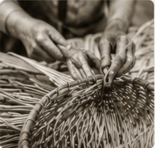 Artisan hands weaving natural fibers into a basket
